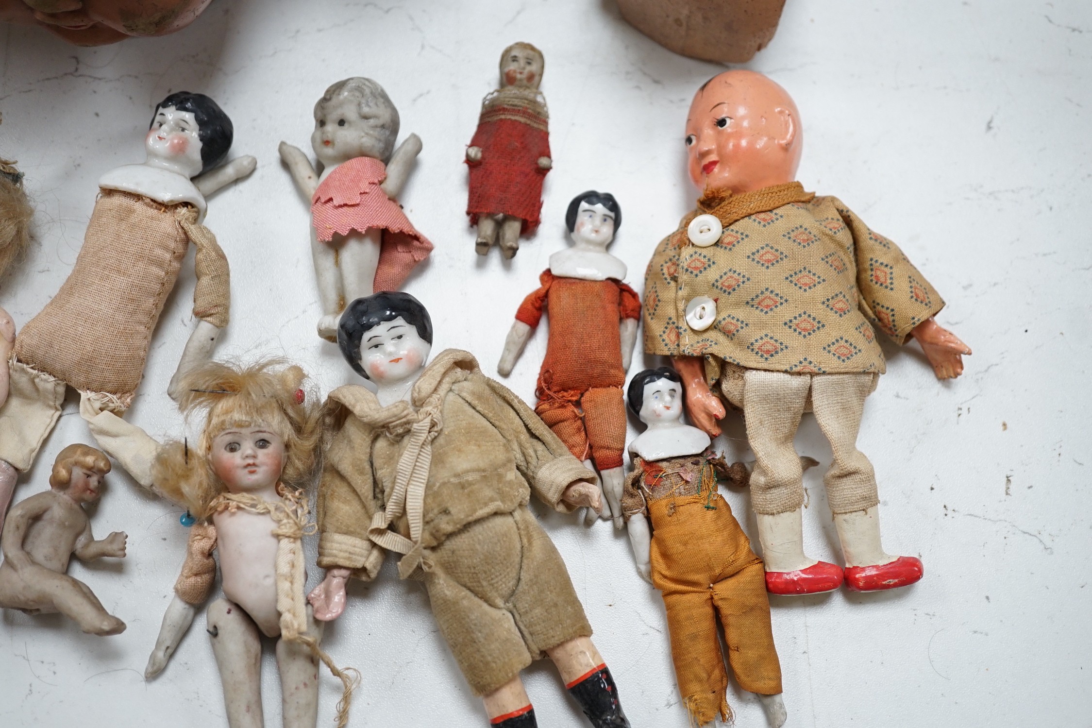 Two Kammer and Reinhardt bisque headed dolls, a wax over composition doll, various other bisque headed dolls and a few single heads and a collection of miniature dolls